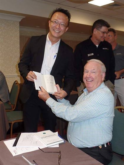 Celebrity author and business strategist Jeff Fox signs his latest book, "How to Be a Rainmaker" for Joe Ng, Operations Manager for MicroCare Asia